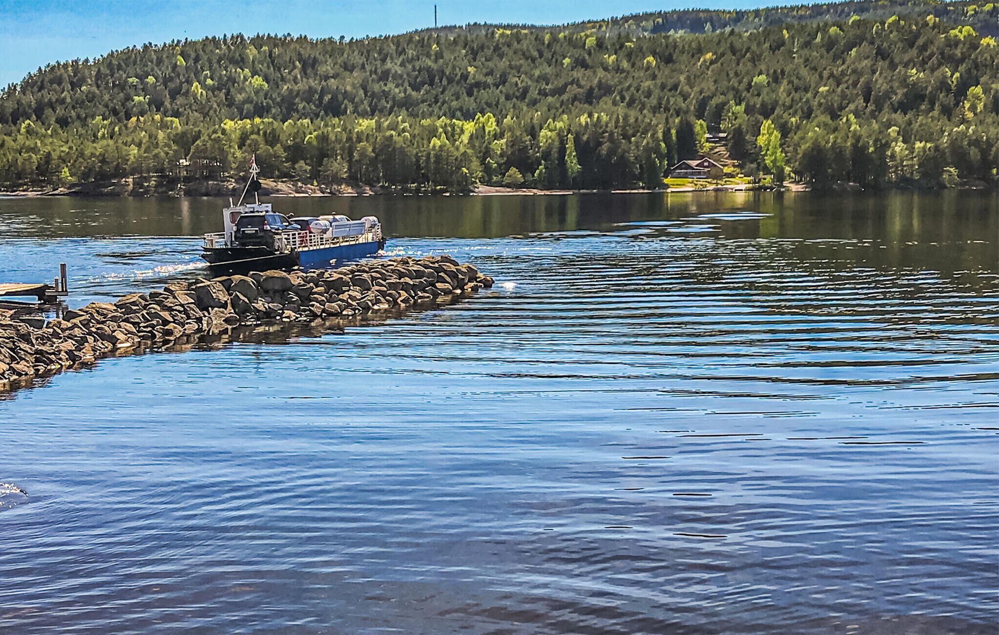 Un bateau était amarré à un quai, avec une colline boisée en arrière-plan.