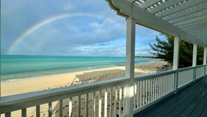 A beach view with a wooden deck and a rainbow. - Caribbean Sandcastle 4 Bedroom Home (Governor's Harbour)