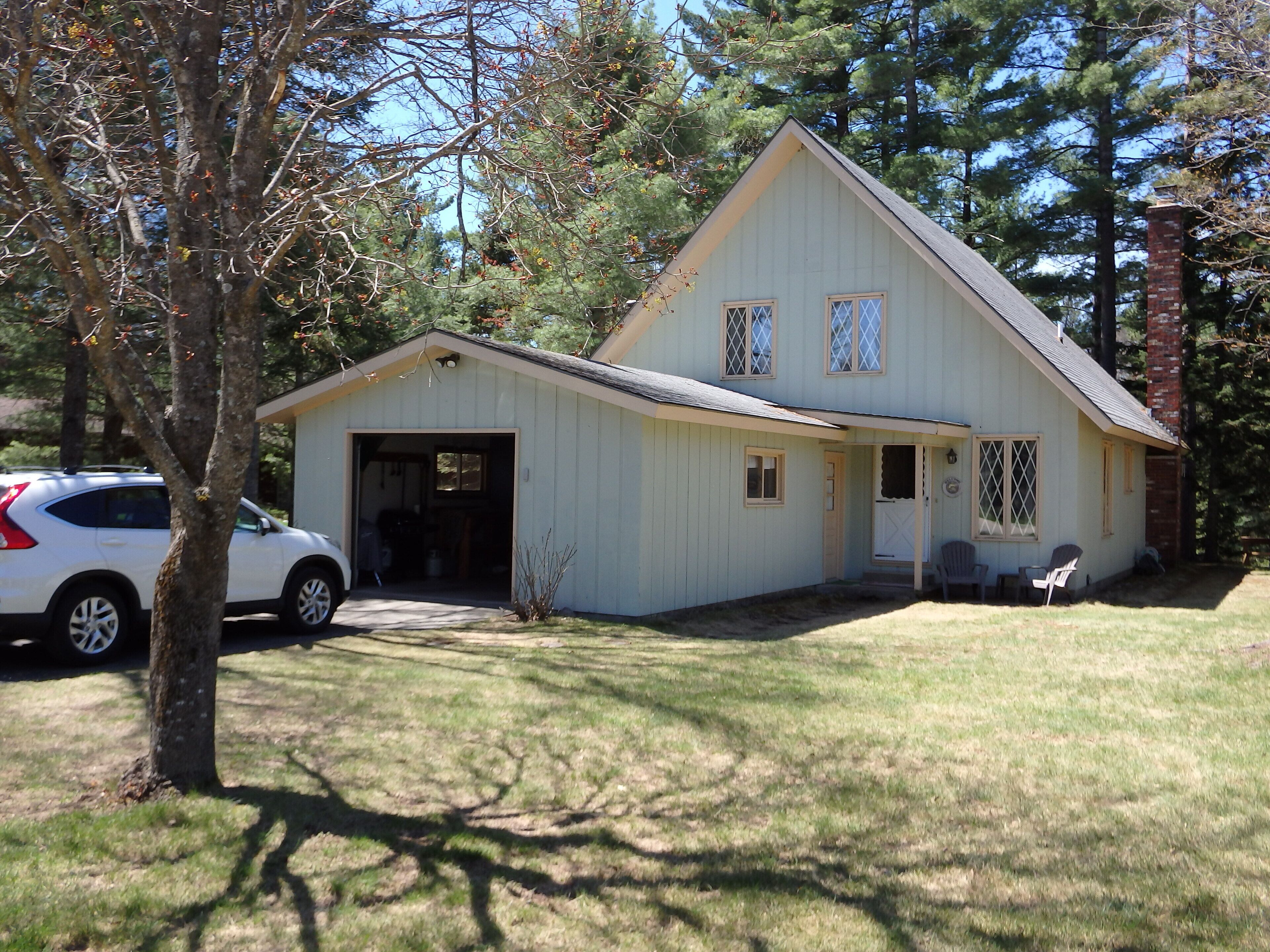 A two-story house with a garage, a covered porch, and a small front yard.