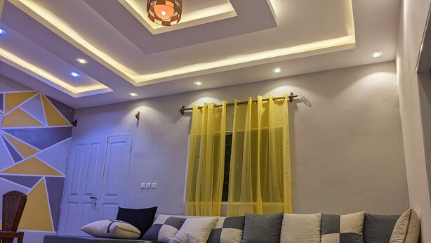 Ein modernes Wohnzimmer mit einer Couch, einem Couchtisch und einer Wand mit Muster.