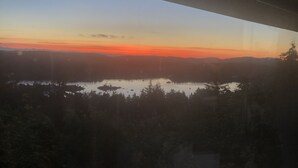 Vista de un lago rodeado de árboles y colinas.