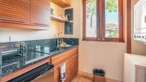 Eine kleine Küche mit Einbauofen, Spüle und Holzschränken.