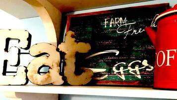 Una estantería con letras decorativas que deletrean "Eat" y un letrero que dice "FARM Fresh".