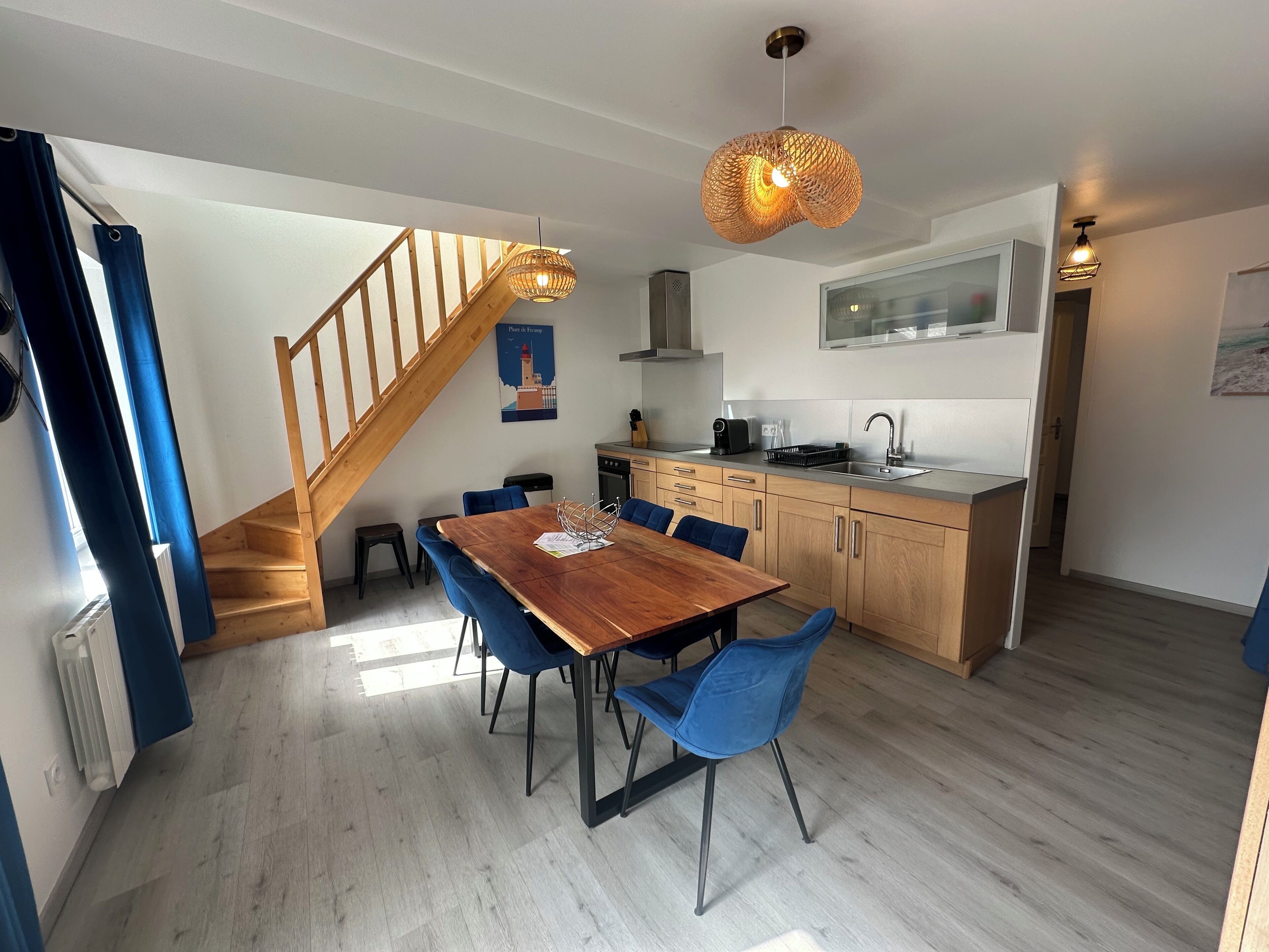 A modern kitchen with wooden cabinets, a built-in oven, and a stainless steel sink.