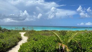 A beach path leading to turquoise waters, surrounded by lush greenery and a clear sky. - French Leave South Beach Dogtrot Villa 2 Bedroom Villa (Governor's Harbour)