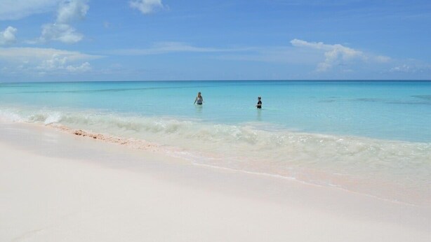 Una playa con agua turquesa cristalina y una orilla arenosa.