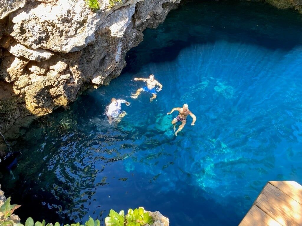 A clear blue pool surrounded by rocky cliffs.