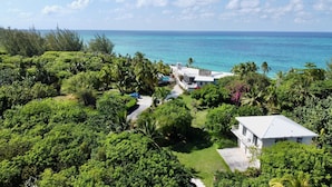 A tropical resort with lush greenery, a pool, and ocean views. - Trident Cottage 2 Bedroom Cottage (North Palmetto Point)