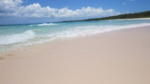 A beach with clear turquoise water and a sandy shore. - Orchid Cottage 2 Bedroom Cottage (Governor's Harbour)