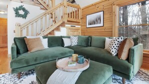 Um sofá modular verde com uma mesa de apoio, um livro e duas canecas.