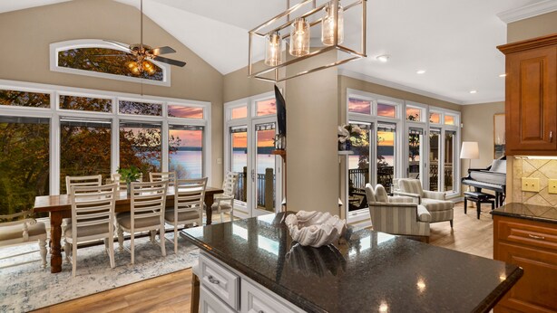 Una cocina amplia con una isla grande, armarios blancos y vistas al exterior.