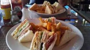 Une assiette de sandwichs et de frites sur une table.