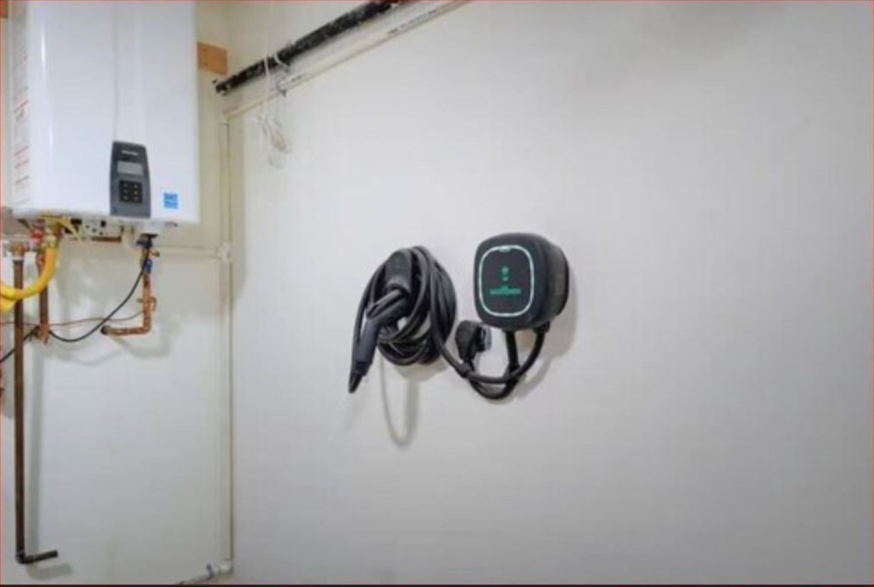 A wall-mounted electrical outlet with a power cord and a device plugged in.