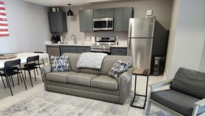 A modern kitchen with grey cabinets, a stainless steel refrigerator, and a built-in microwave. - Golf Close to lakes. 2 bedroom, 2 bath. Sleeps 6 Pool. (Mancelona)