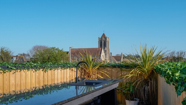 A rooftop pool with a wooden fence and potted plants. - The Old Fish Bar (Margate)