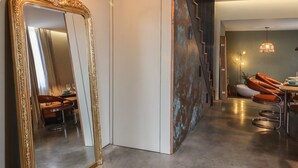 A modern interior with a large ornate mirror, a dining area with leather chairs, and a staircase with a unique metal design. - The Old Fish Bar (Margate)