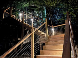 Eine Holztreppe mit Metallgeländern, umgeben von Bäumen.