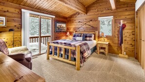 Une chambre confortable dans un chalet en rondins, avec un lit en bois, un bureau et une chaise.