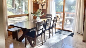 Un coin repas en bois comprenant une table, des chaises et un lustre.