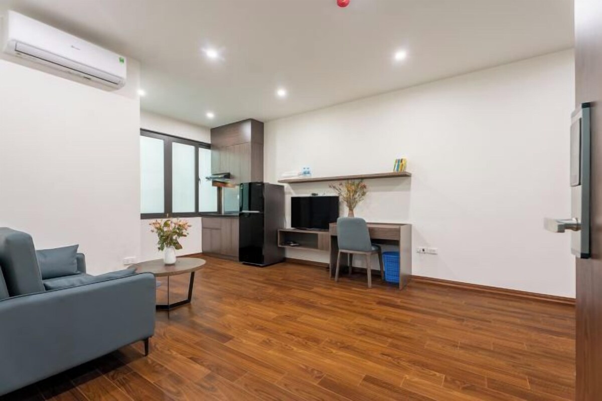 A modern apartment with a living room, a dining area, and a kitchenette.