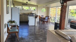 Uma cozinha espaçosa com área de refeições, sofá e uma grande janela com vista para o exterior.