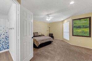 Cozy retreat with a comfortable bed, carpeted floor, and a ceiling fan.