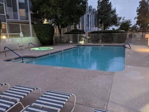 Relax by the pool with lounge chairs and a fence surrounding the area.