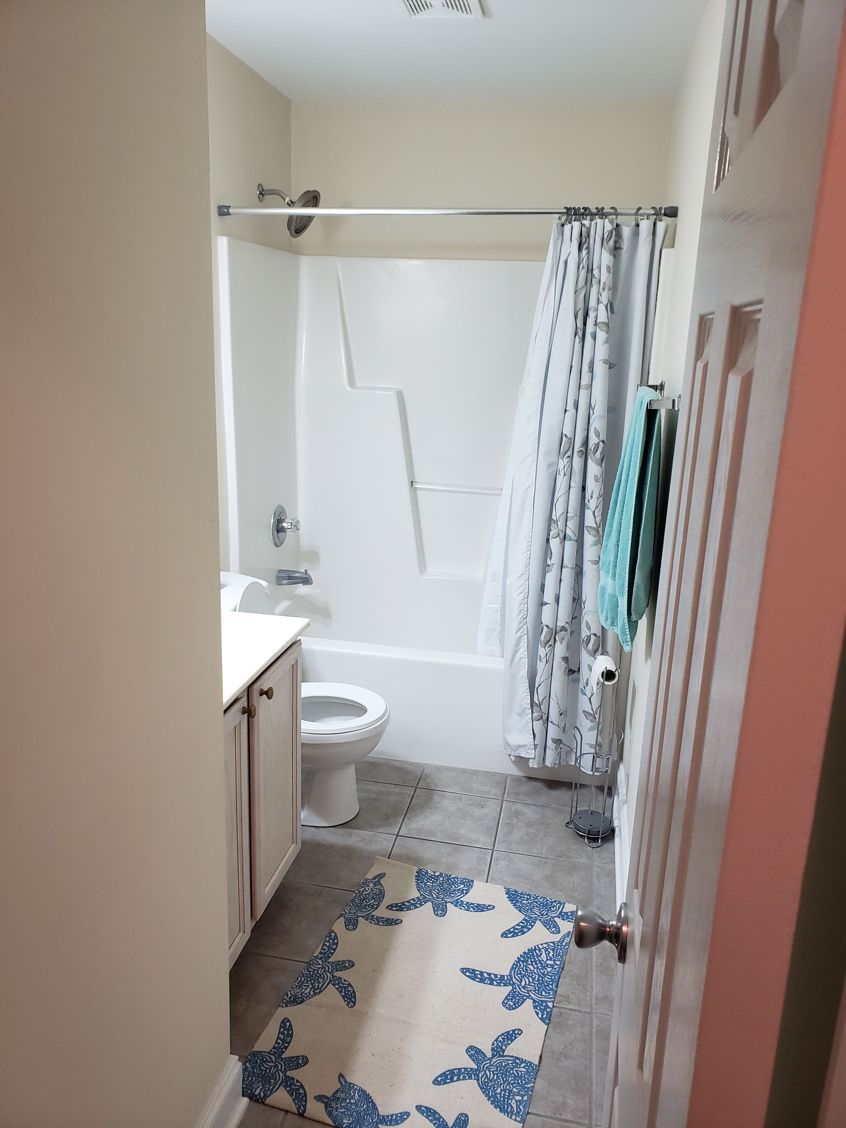 A bathroom with a toilet, bathtub, and shower curtain.