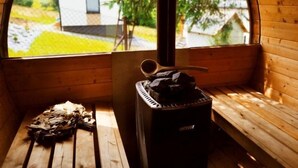 A cozy cabin with a wooden interior, a bench, a heater, and a window offering a view of a house and greenery outside. - Chatka pod Górką by Interhome (Wisla)
