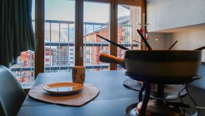 A dining area with a table, a bowl, a plate, and a cup. - Les Genets 163B by Interhome (Nendaz)