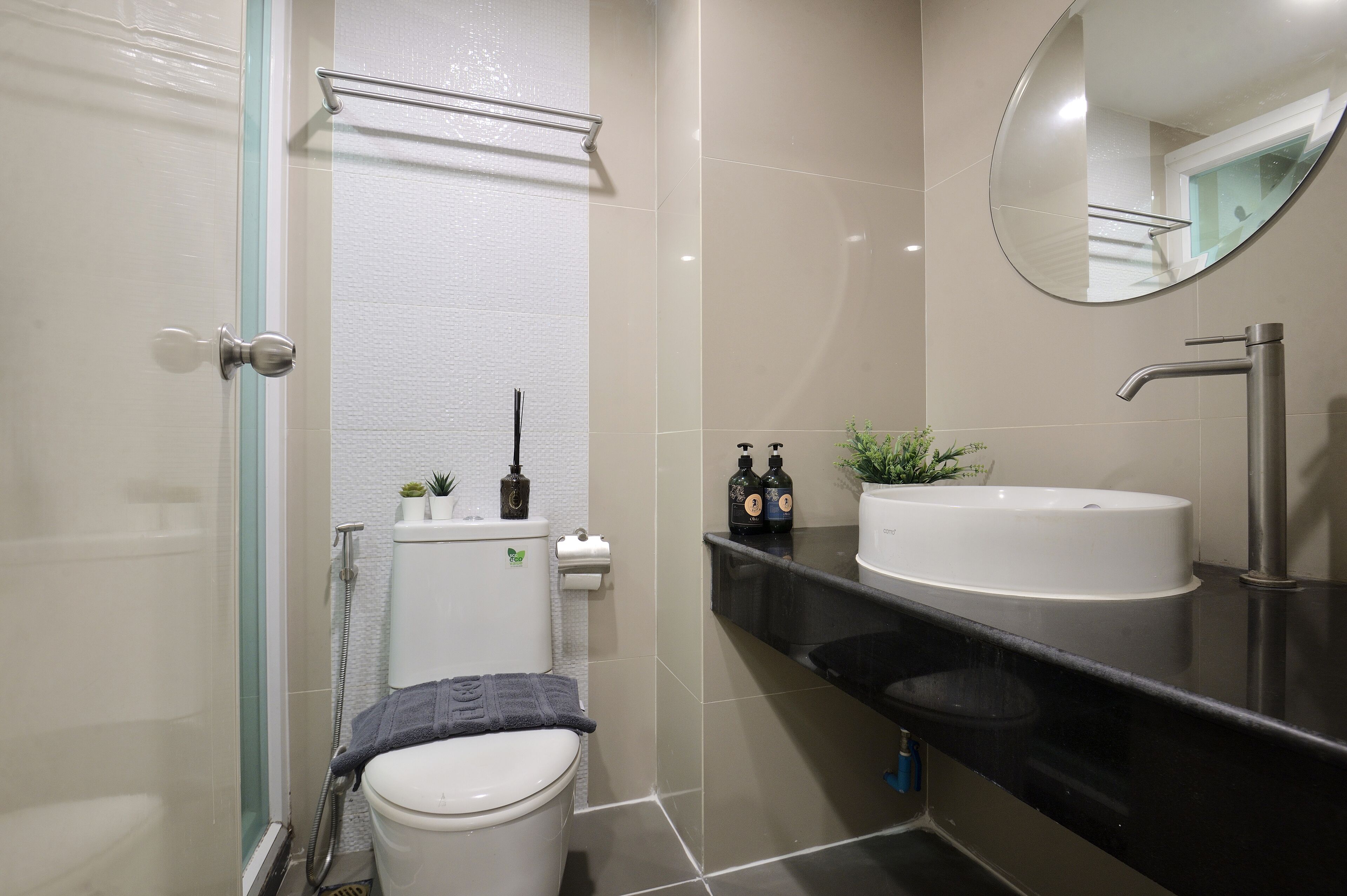 A modern bathroom with a toilet, sink, and shower.