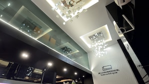 A modern hotel interior with a glass ceiling, recessed lighting, and a visible reception area. - De Lux Bangkok Hotel (Bangkok)