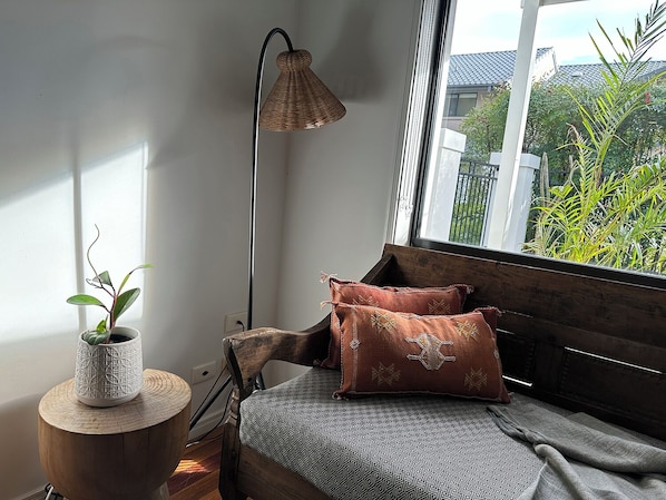 Une pièce chaleureuse avec un banc en bois, une plante en pot et une lampe sur pied.