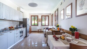 Una cocina moderna con encimeras de granito, electrodomésticos de acero inoxidable y un comedor con una mesa lista para el desayuno.