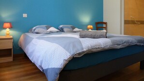 A bedroom with a bed, two bedside tables, and a chair. - Quiet and spacious cottage in the countryside (Fourilles)