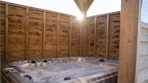 A hot tub with a wooden wall backdrop and a metal frame. - House facing the sea, with swimming pool and SPA
OMAHA GITES (Vierville-sur-Mer)
