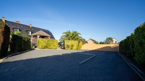 A residential street with houses, a clear sky, and a paved road. - House facing the sea, with swimming pool and SPA
OMAHA GITES (Vierville-sur-Mer)