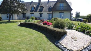 A large, two-story house with a sloped roof, multiple windows, and a balcony. - House facing the sea, with swimming pool and SPA
OMAHA GITES (Vierville-sur-Mer)