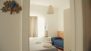 A bedroom with a bed, a nightstand, a lamp, and a wall decoration. - Stella del Sud Guesthouse  (Patu)
