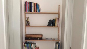 A hallway with a wooden bookshelf containing books and decorative items. - Stella del Sud Guesthouse  (Patu)
