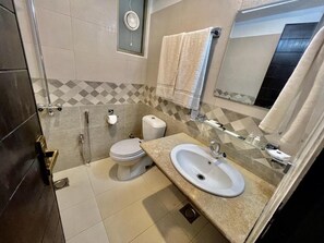 Une salle de bain avec des toilettes, un lavabo et une douche.