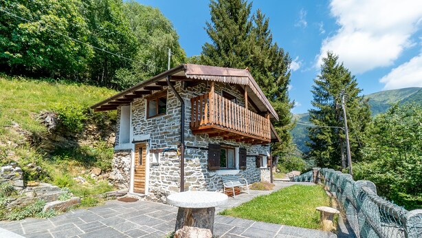 A stone house with a wooden balcony, surrounded by greenery and a stone pathway. - Small rustic dream in a quiet location with a view of the mountains (Indemini)