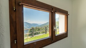 A room with a wooden-framed window overlooking a mountainous landscape. - Small rustic dream in a quiet location with a view of the mountains (Indemini)