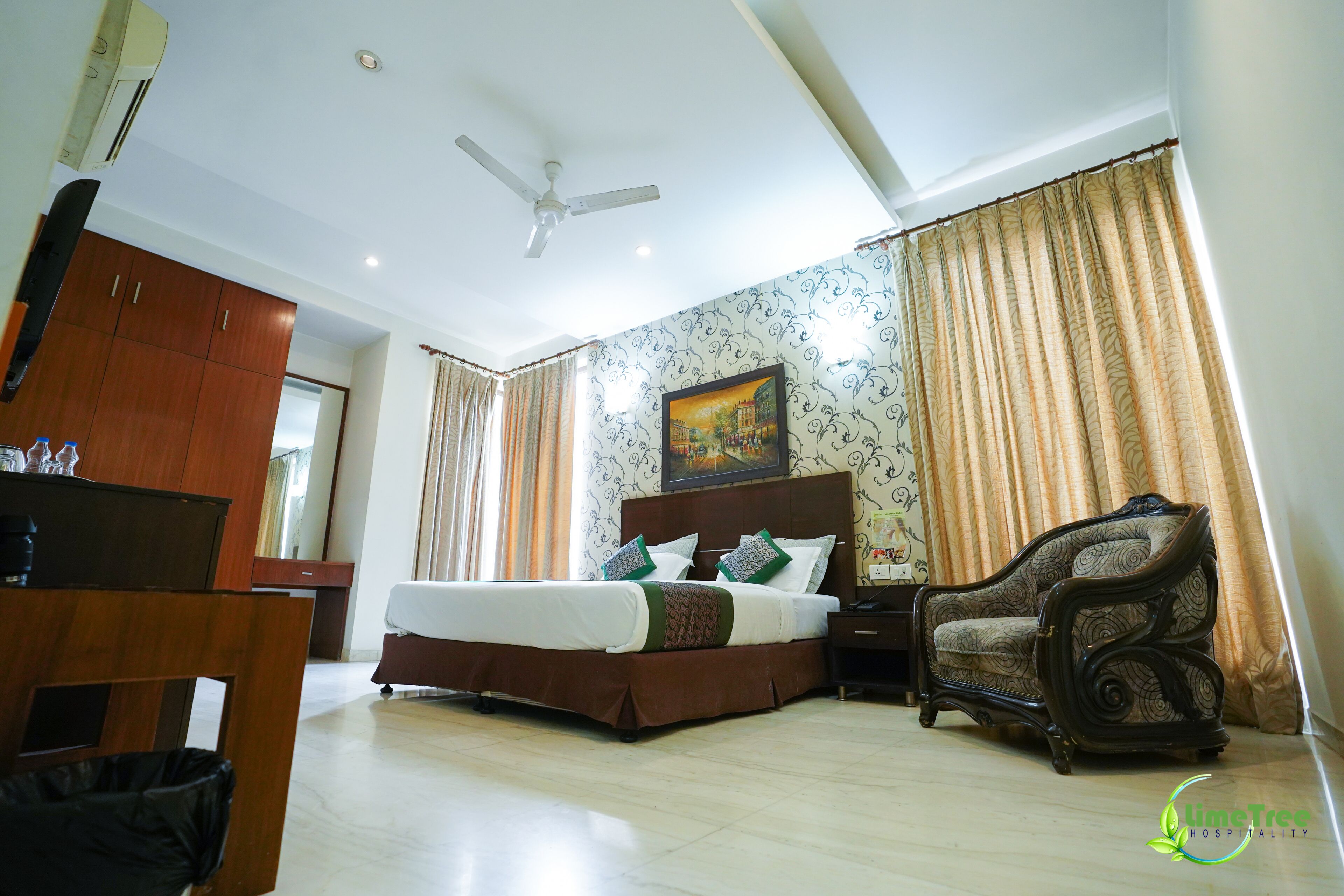 Une chambre d’hôtel avec un lit, une chaise, un bureau et une armoire.