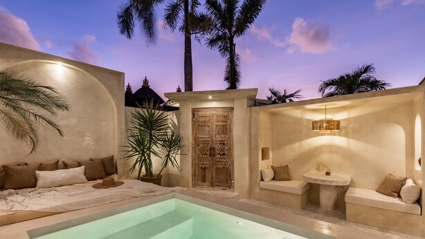 A serene bedroom with a large bed, a small sitting area, and a pool. - Luxe & Unique honeymoon Bocami Suites- 2 by OriVista (Kerobokan)