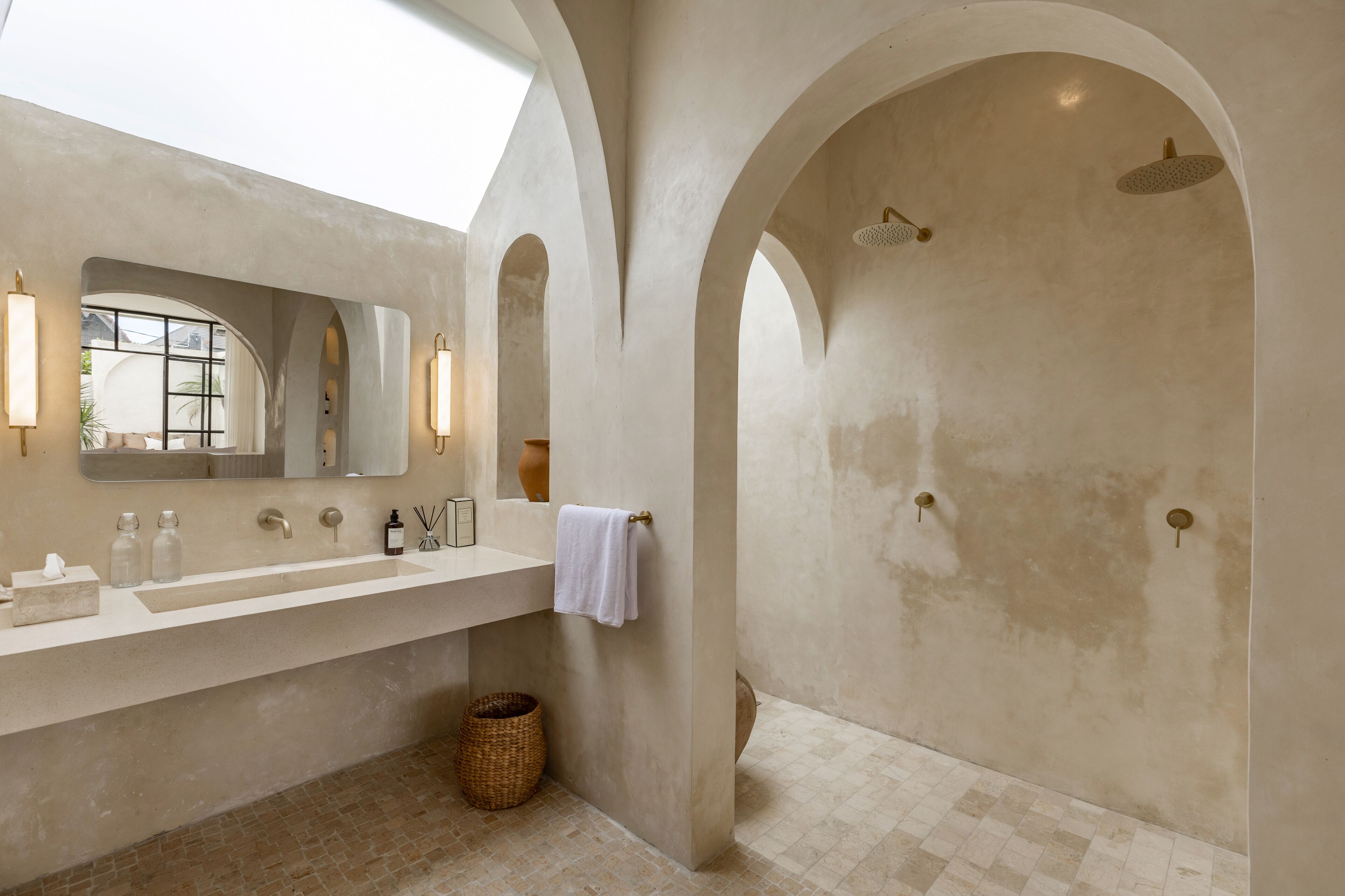 A modern bathroom with a large sink, mirror, and shower area.