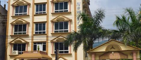 A multi-story hotel with a prominent entrance and a sign reading "Hotel New Era."