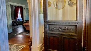 A room with a wooden door, a mirror, and a framed picture on the wall. - Historic 1884 Victorian Downstairs Unit. Walk to everything! Close to elk! (Saint Marys)