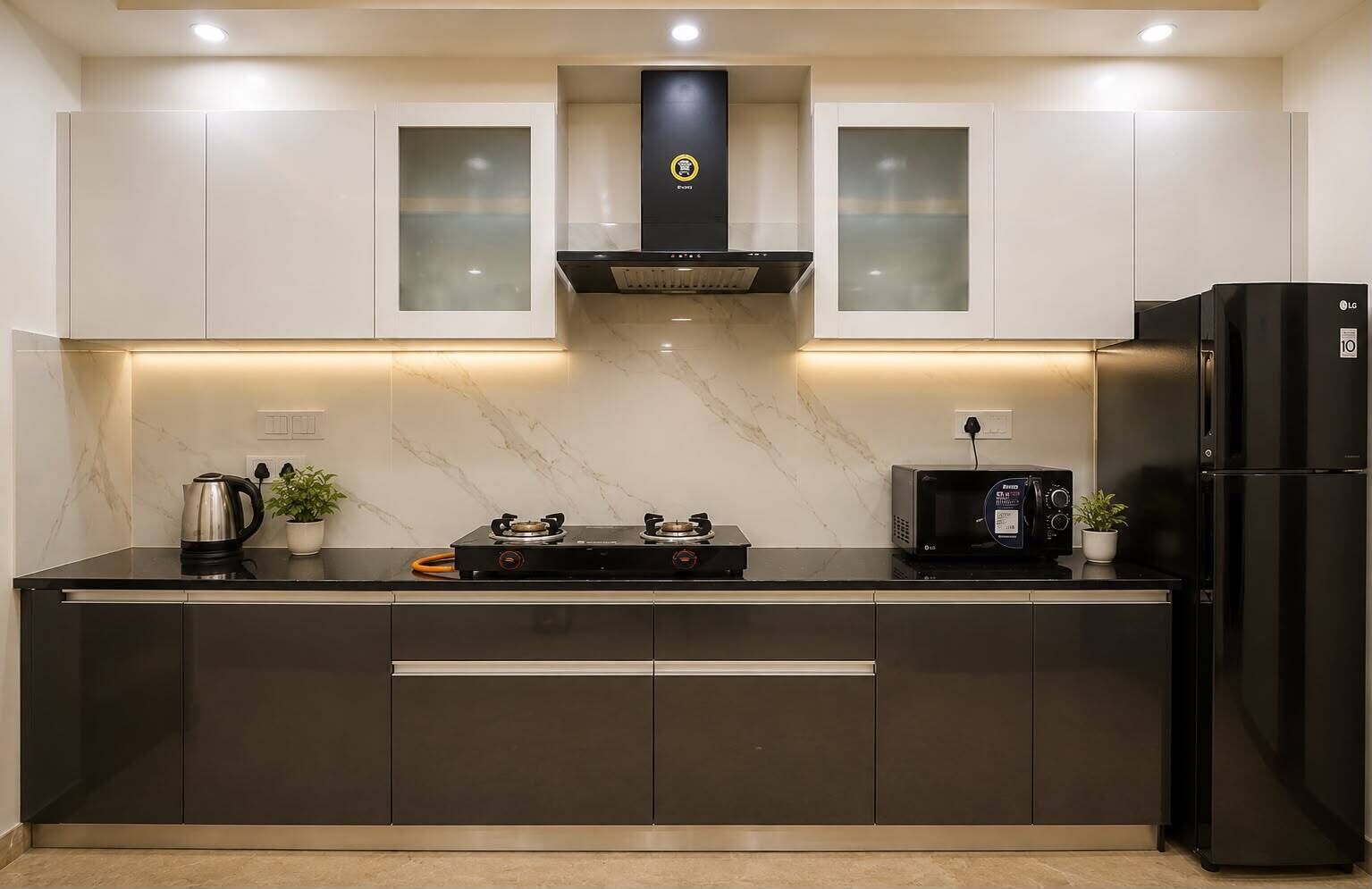 A modern kitchen with a gas stove, microwave, and black refrigerator.
