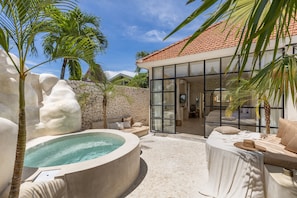 A spa area with a hot tub, seating, and a glass-enclosed room. - Luxe & Unique Honeymoon Bocami Suites-1 By OriVista (Kerobokan)